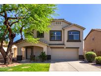 Inviting two-story home featuring desert landscaping, mature tree, covered porch and a two car garage at 11455 E Persimmon Ave, Mesa, AZ 85212