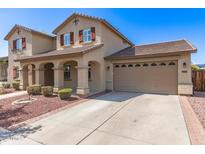 Charming two-story home featuring a spacious driveway, a two-car garage, and well-maintained landscaping at 14440 W Cholla St, Surprise, AZ 85379