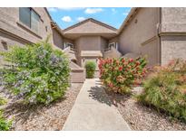 Charming condo exterior featuring colorful landscaping and well-maintained stucco facade at 15151 N Frank Lloyd Wright Blvd # 1088, Scottsdale, AZ 85260