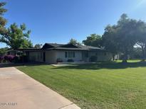 Charming single-story home featuring lush green lawn, a carport, and a neutral exterior paint at 2350 E Melrose St, Gilbert, AZ 85297
