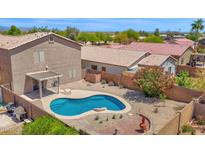 Inviting backyard featuring a kidney shaped blue pool, desert landscaping, and covered patio perfect for outdoor relaxation at 30032 N Desert Willow Blvd, San Tan Valley, AZ 85143