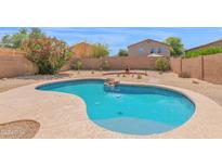 Inviting backyard pool area with a charming rock feature and desert landscaping at 30032 N Desert Willow Blvd, San Tan Valley, AZ 85143