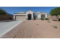 Charming single-story home featuring a low-maintenance desert landscape and a two-car garage at 30560 W Weldon Ave, Buckeye, AZ 85396