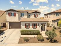 Two-story home featuring brown accents, red shutters, and a two-car garage at 31156 N 137Th Ln, Peoria, AZ 85383