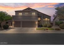 Night shot of a home with a three-car garage, well-maintained lawn, and manicured bushes at 3812 N Barron --, Mesa, AZ 85207