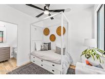 Modern bedroom with a stylish canopy bed, ceiling fan, and minimalist decor at 4220 N 32Nd St # 2, Phoenix, AZ 85018