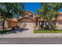 Two-story home featuring a red tile roof, a well-manicured lawn, and a spacious two-car garage at 6462 E Raftriver St, Mesa, AZ 85215