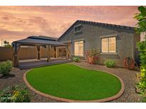 Backyard features a covered patio and lush artificial grass for easy maintenance at 8872 W Hollywood Ave, Peoria, AZ 85345