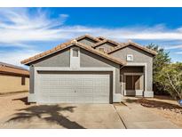 Charming single-story home featuring a two-car garage, desert landscaping, and a tile roof at 15339 N 148Th Ct, Surprise, AZ 85379