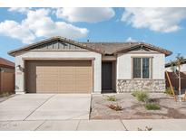 Charming single-story home featuring a neutral color palette, stone accents, and a well-maintained front yard at 15627 W Hackamore Dr, Surprise, AZ 85387