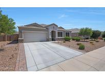Charming single-story home showcasing a well-manicured lawn and a spacious two-car garage with a wide driveway at 30446 W Picadilly Rd, Buckeye, AZ 85396
