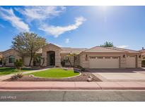 Charming single-story home featuring a desert landscape, mature tree, and a spacious three-car garage at 4055 N Recker Rd # 62, Mesa, AZ 85215