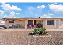 Spacious covered patio with tile flooring, ceiling fan, and outdoor seating, overlooking the desert landscaped backyard at 6237 E Boston St, Mesa, AZ 85205