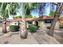 Charming single-story home with a beautiful red tile roof, desert landscaping, and mature trees at 7521 S College Ave, Tempe, AZ 85283