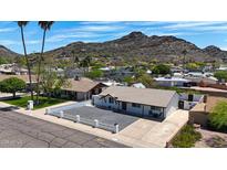 Charming single-story home featuring a rock driveway and a bright white fence, nestled in a peaceful neighborhood with a mountain backdrop at 1511 E Carol Ave, Phoenix, AZ 85020