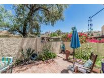 Quaint brick patio featuring a vibrant garden, comfortable seating, and stucco wall at 1808 E Hayward Ave # 1, Phoenix, AZ 85020