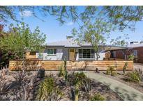 Charming home exterior with a yellow door, mature landscaping and a wooden fence at 2039 N 12Th St, Phoenix, AZ 85006