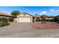 Charming single-story home featuring a well-maintained yard and a neutral-toned exterior with a two-car garage at 20717 N 104Th Ln, Peoria, AZ 85382