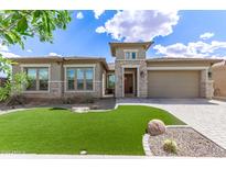 Beautiful single-story home featuring a manicured lawn and desert landscaping with a neutral color palette at 22825 E Mewes Rd, Queen Creek, AZ 85142