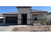 Charming single-story home with a covered porch, neutral palette, and well-manicured front yard at 25473 W Graham Trl, Buckeye, AZ 85326