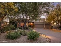 Charming home featuring desert landscaping with mature trees and a spacious driveway to a two-car garage at 29412 N 108Th Pl, Scottsdale, AZ 85262