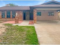 Charming single-story home with a brick facade and a well-maintained front yard at 4349 W Morten Ave, Glendale, AZ 85301