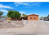Charming single-story home with a well-manicured yard and an expansive driveway at 654 W Plata Ave, Mesa, AZ 85210