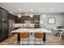 Modern kitchen with large island, stainless steel appliances, and dark wood cabinets at 7464 E Paraiso Dr, Scottsdale, AZ 85255