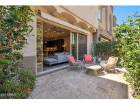 Cozy outdoor patio with comfortable seating area and a view into the home's living space at 7464 E Paraiso Dr, Scottsdale, AZ 85255