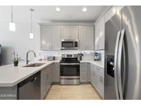 Modern kitchen featuring gray cabinets, stainless steel appliances, a white countertop, and tile flooring at 7531 E Billings St # 116, Mesa, AZ 85207