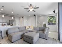Bright living room featuring a comfortable gray sectional sofa and an open floor plan at 7531 E Billings St # 116, Mesa, AZ 85207