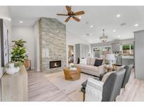 Bright living room features a stone fireplace, ceiling fan and neutral furniture at 9223 E Camino Del Santo --, Scottsdale, AZ 85260