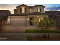 Charming two-story home showcasing stone accents, a two-car garage, and well-manicured landscaping at 15626 W Georgia Dr, Surprise, AZ 85379