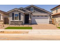 Charming single-story home featuring a two-car garage, stone accents, and a well-maintained lawn at 15784 W Georgia W Dr, Surprise, AZ 85379