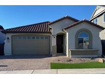 Charming single-story home with a two-car garage, well-manicured lawn, and classic architectural details at 15796 W Georgia W Dr, Surprise, AZ 85379