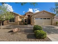 Inviting single-story home with desert landscaping, a two-car garage, and a neutral-toned exterior under a clear blue sky at 3003 E Ironside Ln, Gilbert, AZ 85298