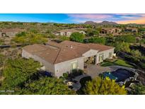 Expansive desert home features a pool, fire pit, outdoor kitchen, and landscaped backyard at 37308 N 100Th Pl, Scottsdale, AZ 85262
