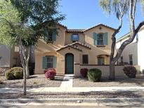 Inviting two-story home featuring colorful flower beds, a charming entryway, and turquoise shutters at 4056 E Devon Dr, Gilbert, AZ 85296