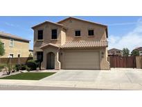Inviting two-story home featuring a tile roof, two-car garage, and well-maintained landscaping at 6808 W Maldonado Rd, Laveen, AZ 85339