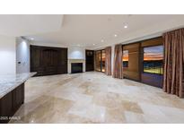 Bright living room with fireplace, custom cabinetry, and balcony overlooking city skyline at 7175 E Camelback Rd # 902, Scottsdale, AZ 85251