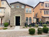 Charming two-story home featuring a stone facade, front patio, and desert landscaping at 7734 W Terri Lee Dr, Phoenix, AZ 85035