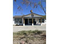 Charming single-story home features a cozy front porch with rustic wood columns and mature landscaping at 1836 W Las Palmaritas Dr, Phoenix, AZ 85021