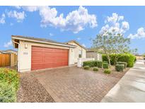 Lovely single-story home with a red garage door, desert landscaping, and a brick driveway at 22560 E Rosa Rd, Queen Creek, AZ 85142