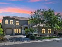 Charming two-story home featuring a well-manicured lawn, mature trees, and a private two-car garage at 3221 E Lynx Pl, Chandler, AZ 85249