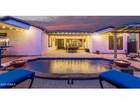 Beautiful pool surrounded by lounge chairs, backyard with lights, and outdoor seating area at 4282 N 180Th Dr, Goodyear, AZ 85395