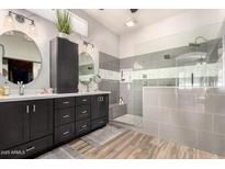 Sleek primary bath with dual vanities, soaking tub, and glass-enclosed shower with grey tile at 4706 E Des Moines St, Mesa, AZ 85205