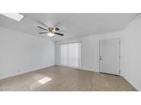 Bright, airy living room with tile floors, ceiling fan, and sliding glass door with vertical blinds at 5229 W Palo Verde Ave, Glendale, AZ 85302