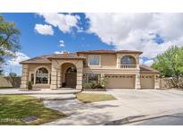 Beautiful two-story home featuring a three-car garage and a well-manicured front yard on a sunny day at 5510 N 132Nd Dr, Litchfield Park, AZ 85340