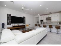 Open-concept living room with white sofa, sleek TV, and modern decor at 7347 E Vista Bonita Dr, Scottsdale, AZ 85255