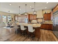 Spacious kitchen featuring wood cabinets, granite countertops, stainless steel appliances, and a breakfast bar at 7425 W Caro Rd, Glendale, AZ 85308